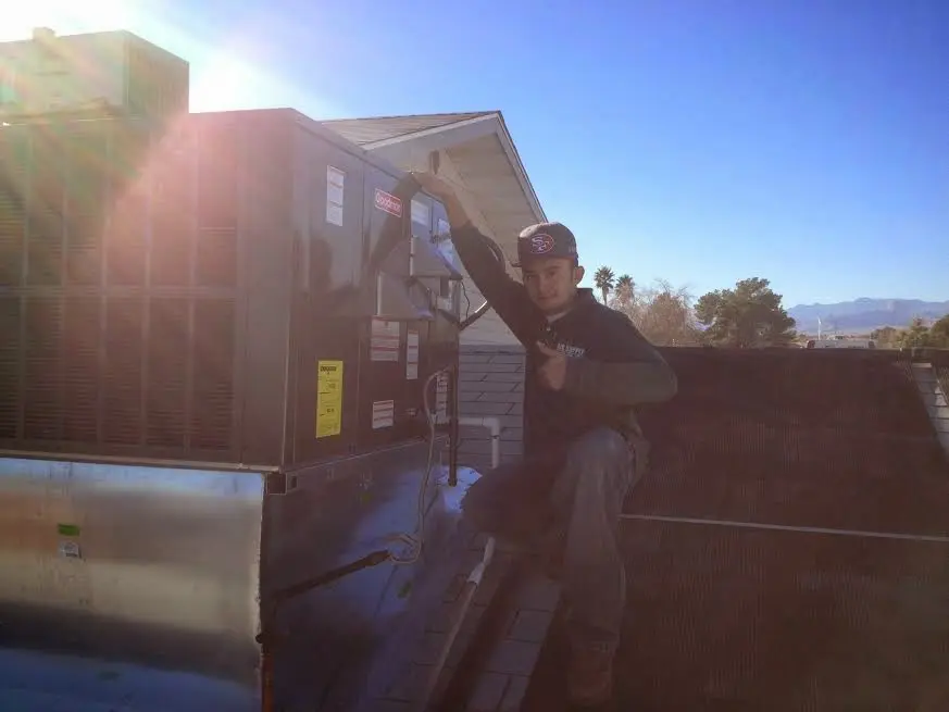HVAC technician performing Air Duct Repair on a rooftop unit in West Valley City